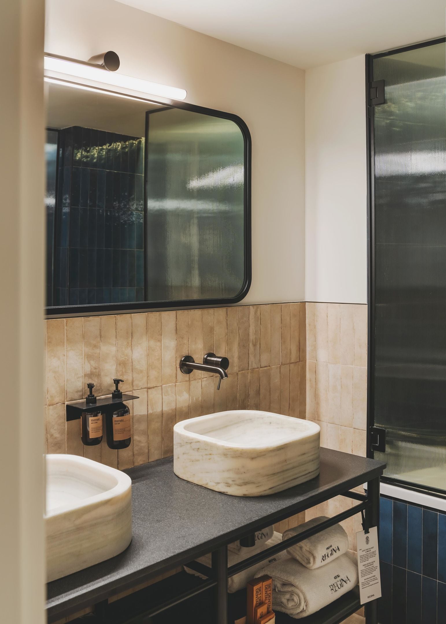 A bathroom with two sinks, a mirror, and a towel rack.