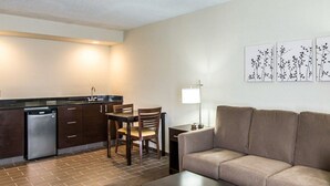 A compact living space with a kitchenette, a sofa, a coffee table, and a dining area.