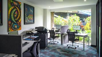 A modern office space with cubicles, computers, and artwork on the walls.