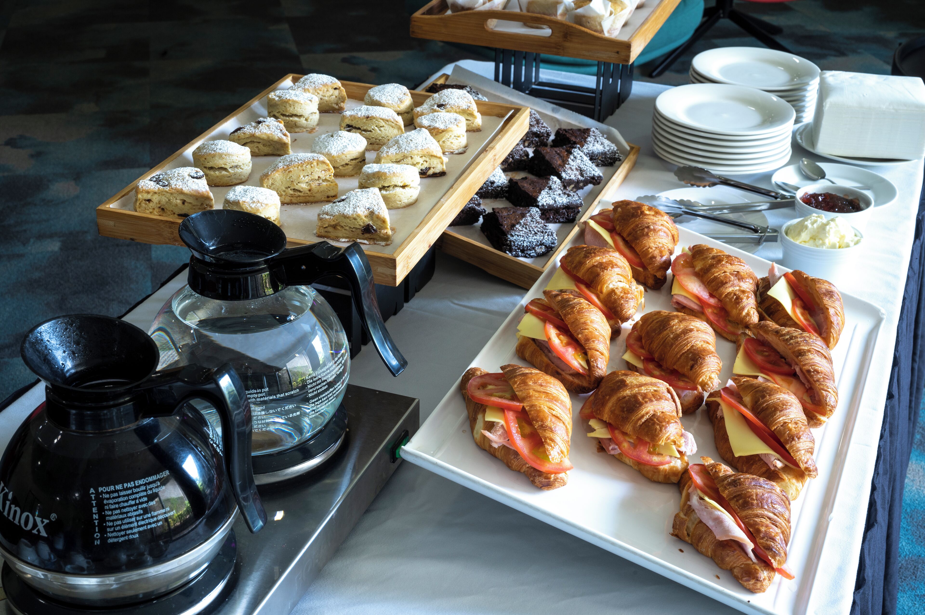 Un buffet de petit-déjeuner proposant des viennoiseries, des sandwichs et un coin café.
