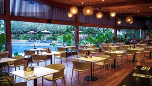 A restaurant with outdoor seating, wooden flooring, and hanging pendant lights. - Holiday Inn Port Moresby by IHG (Port Moresby)