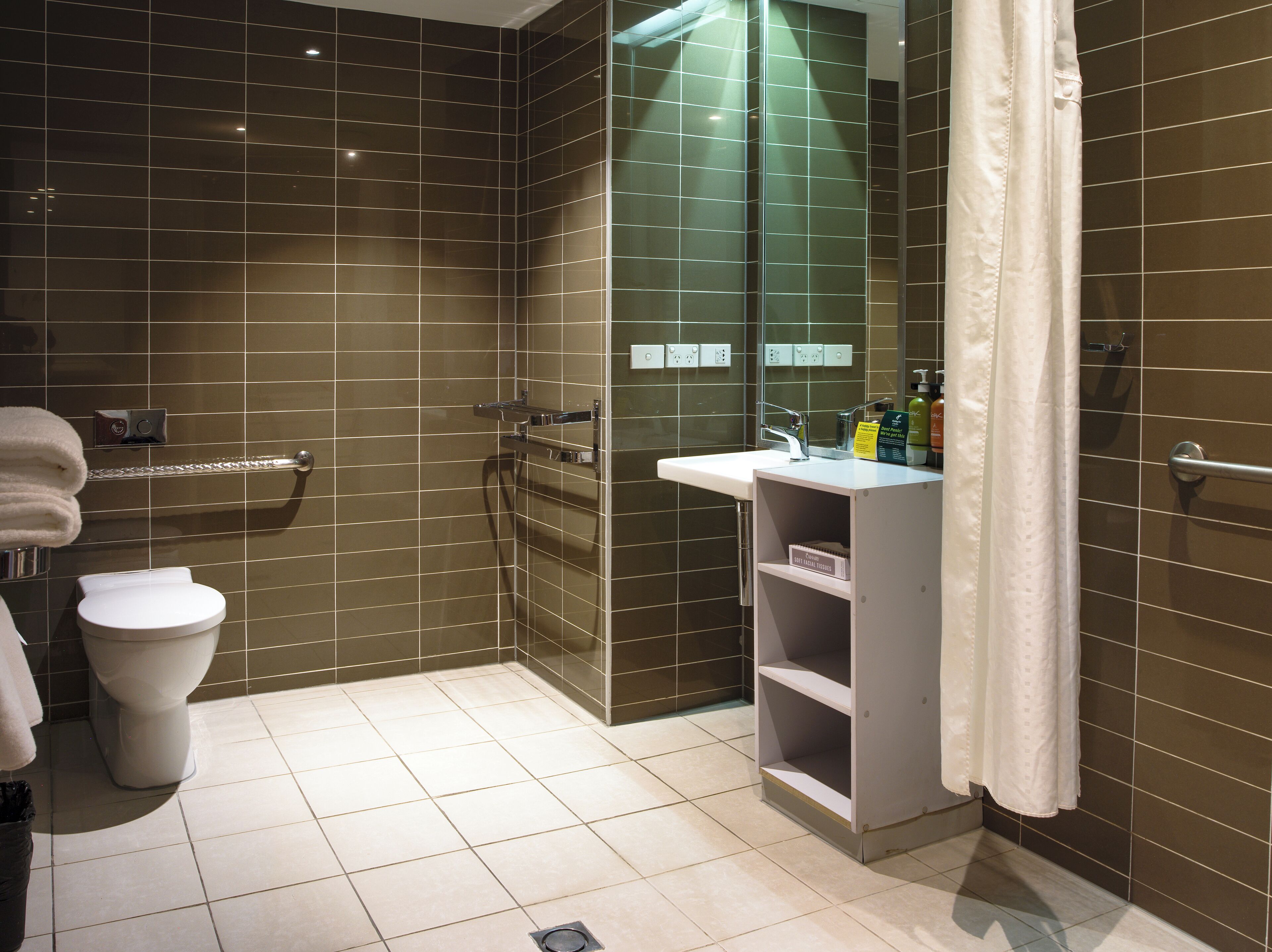 A modern bathroom with a toilet, sink, and shower area.