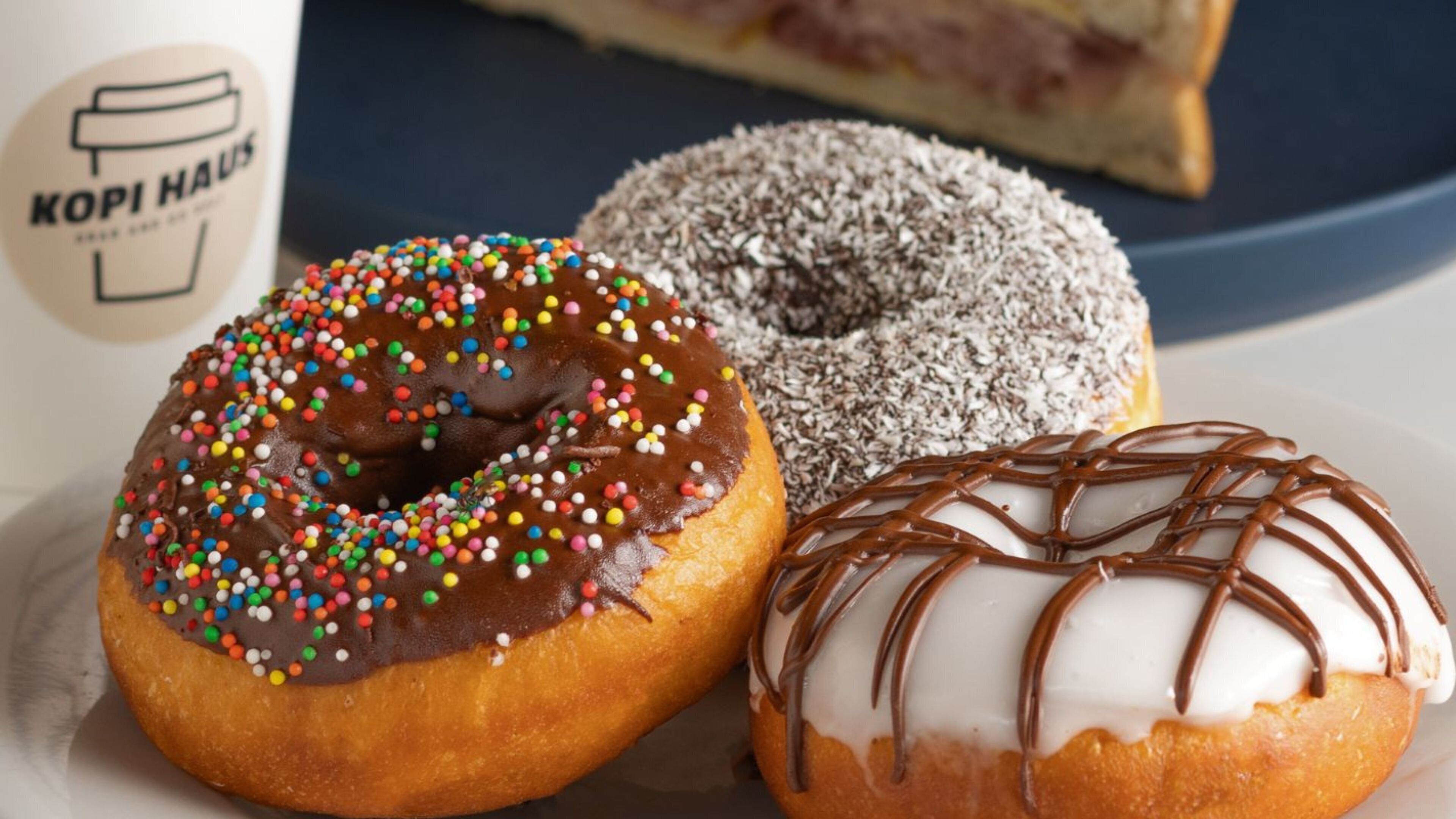 Three donuts with different toppings on a plate.