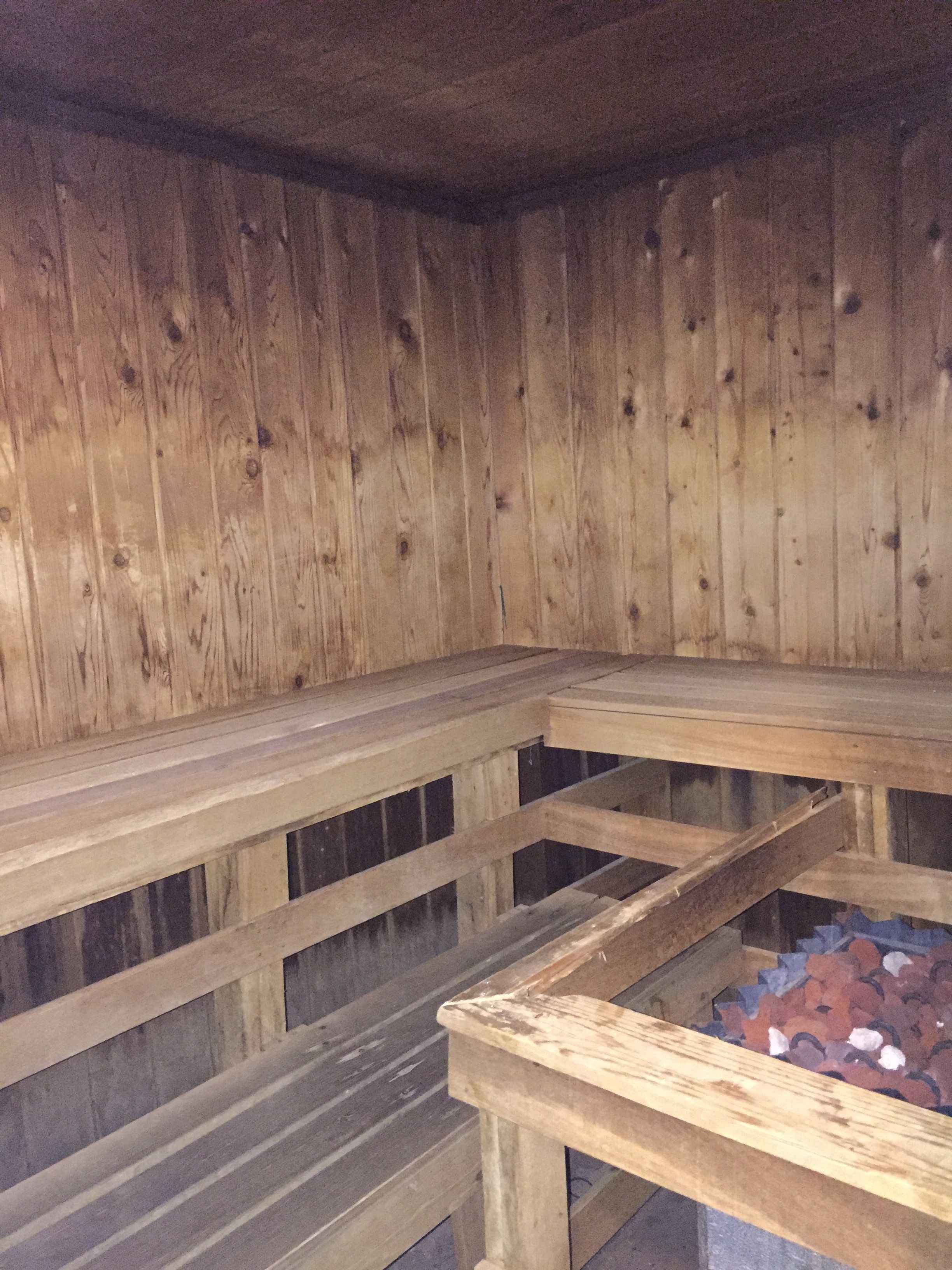 A sauna with wooden benches and a stone floor.