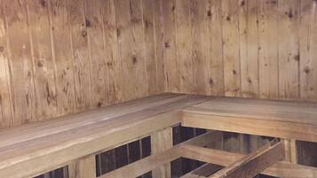 A sauna with wooden benches and a stone floor.