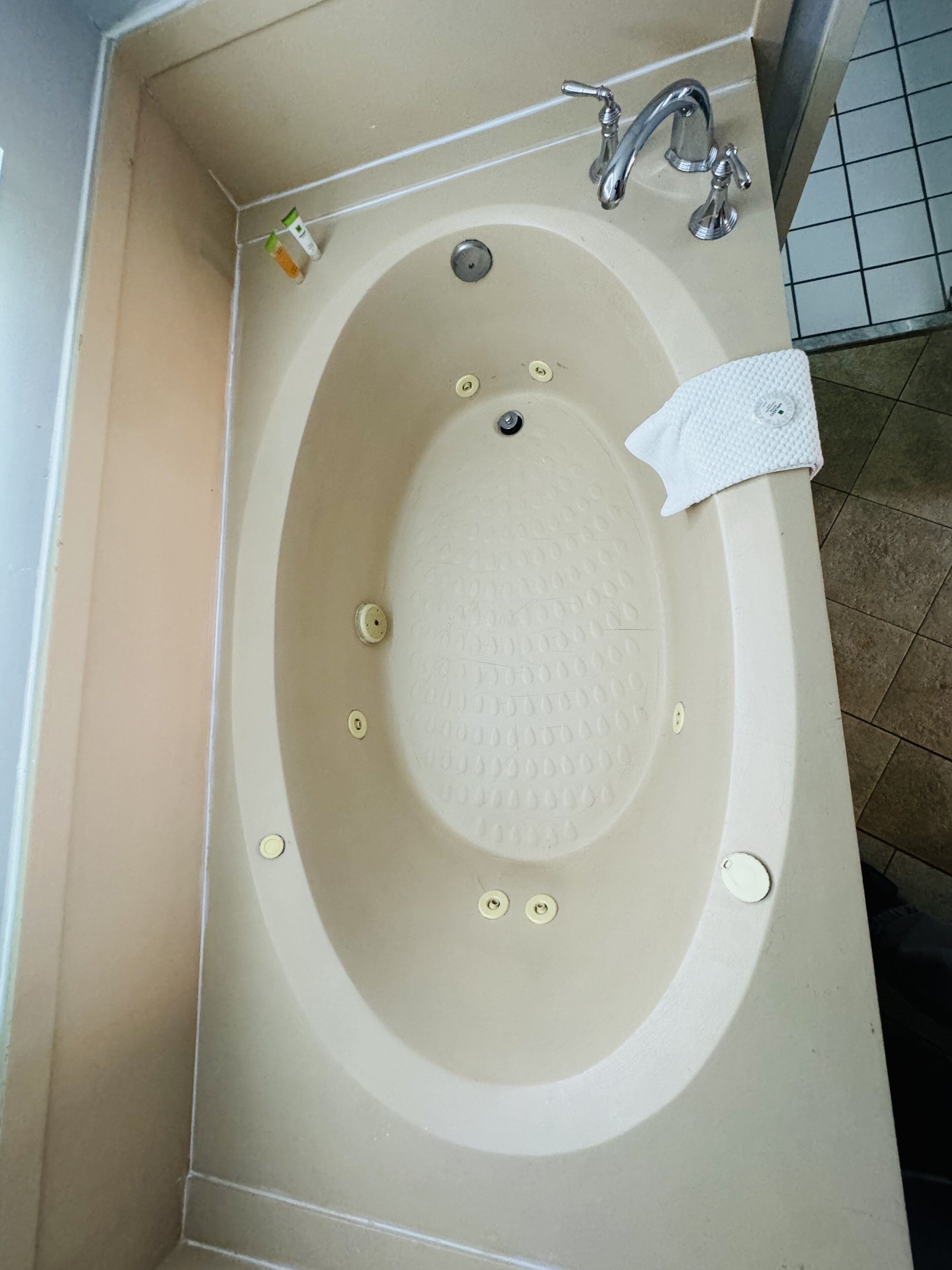 Una bañera con grifo y toalla.