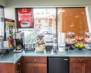 A breakfast bar with a coffee machine, toaster, and various food items.