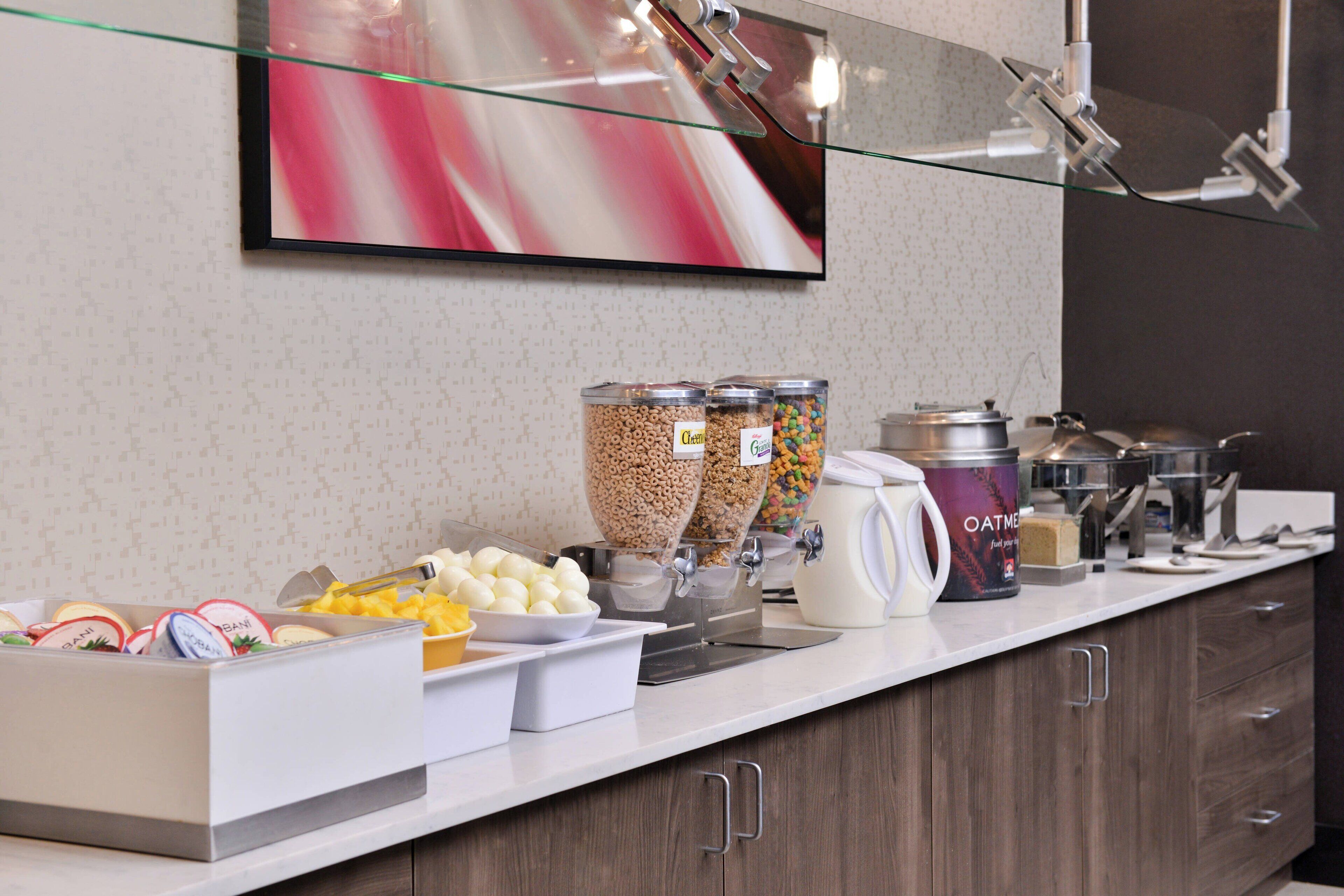 A breakfast buffet setup with various food items and containers.