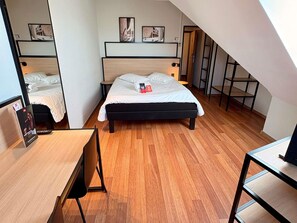 A bedroom with a bed, a desk, and a chair. There are framed pictures on the wall. - ibis Nuernberg Altstadt (Nuremberg)