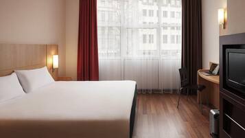 Ropa de cama hipoalergénica y caja de seguridad en la habitación