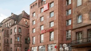 A hotel building with multiple floors, large windows, and a prominent red 'ibis HOTEL' sign. - ibis Nuernberg Altstadt (Nuremberg)