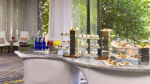 Un hall d’hôtel moderne doté d’un comptoir vitré où sont exposés divers en-cas et boissons.
