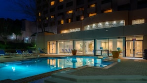 Un hôtel doté d’une piscine, d’un espace extérieur aménagé et d’une entrée bien éclairée.