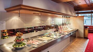 A buffet setup with various food items and a menu board.