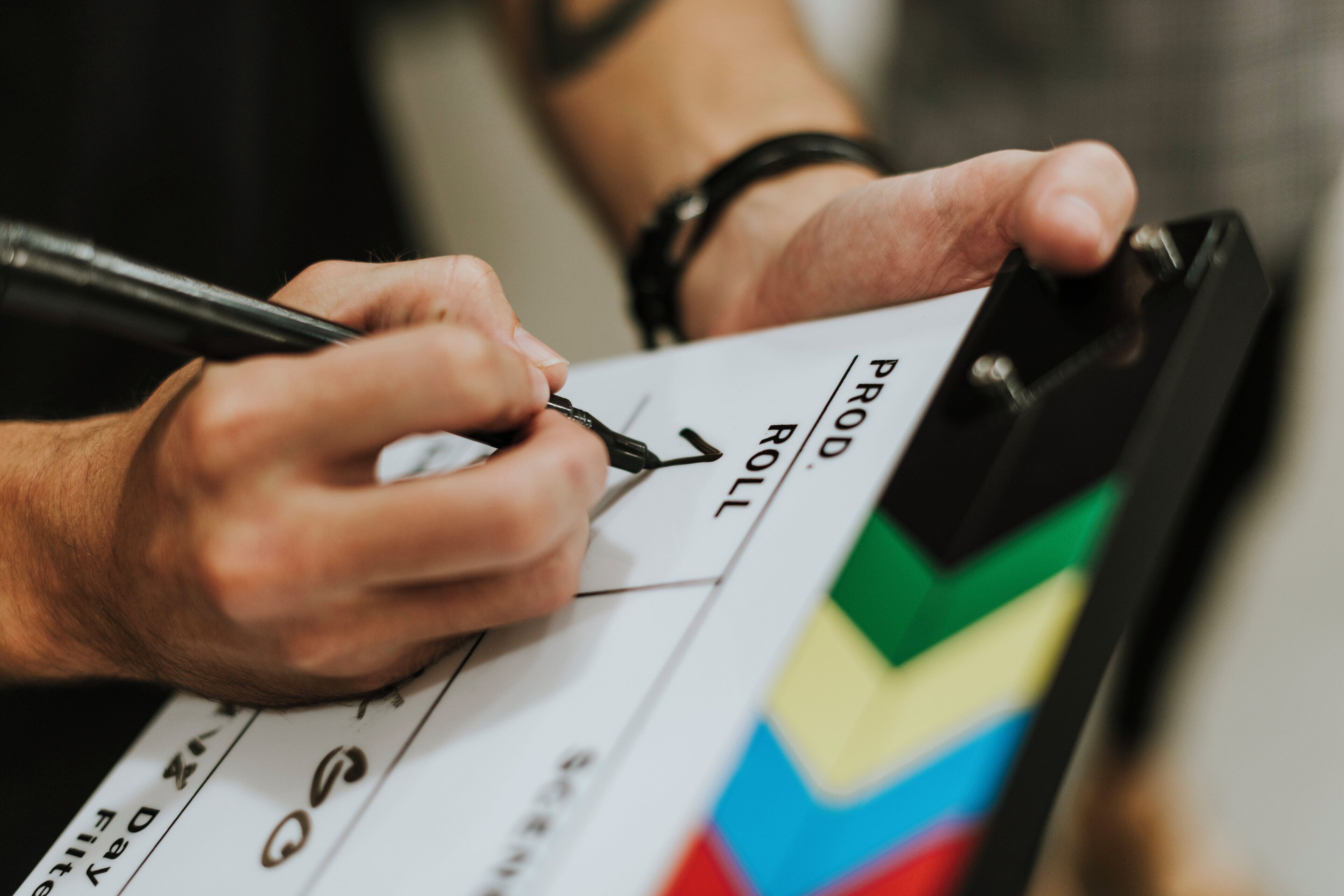 A person marking a clapperboard with a pen.