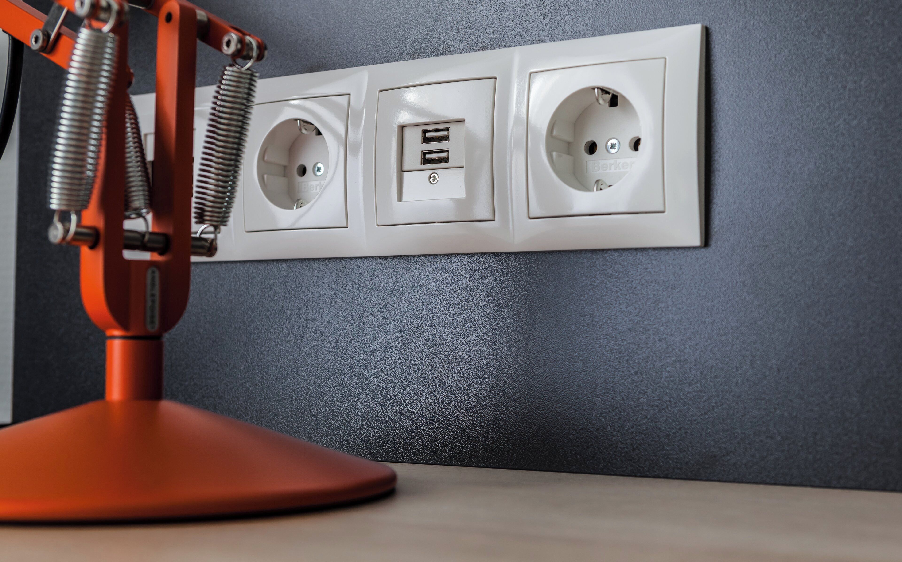 A wall-mounted electrical outlet with two USB ports and a standard electrical outlet, accompanied by a red lamp.