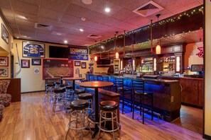 A bar area with stools, a counter, and sports memorabilia.