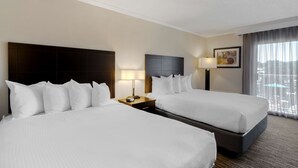 A hotel room with two beds, a nightstand with a lamp, a painting on the wall, and a window with curtains.