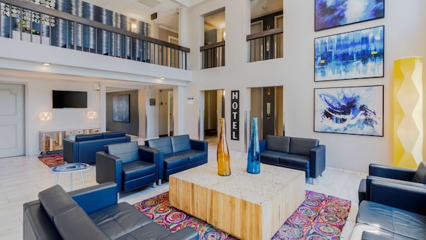 A spacious lobby with multiple seating areas, a central coffee table, and artwork on the walls.