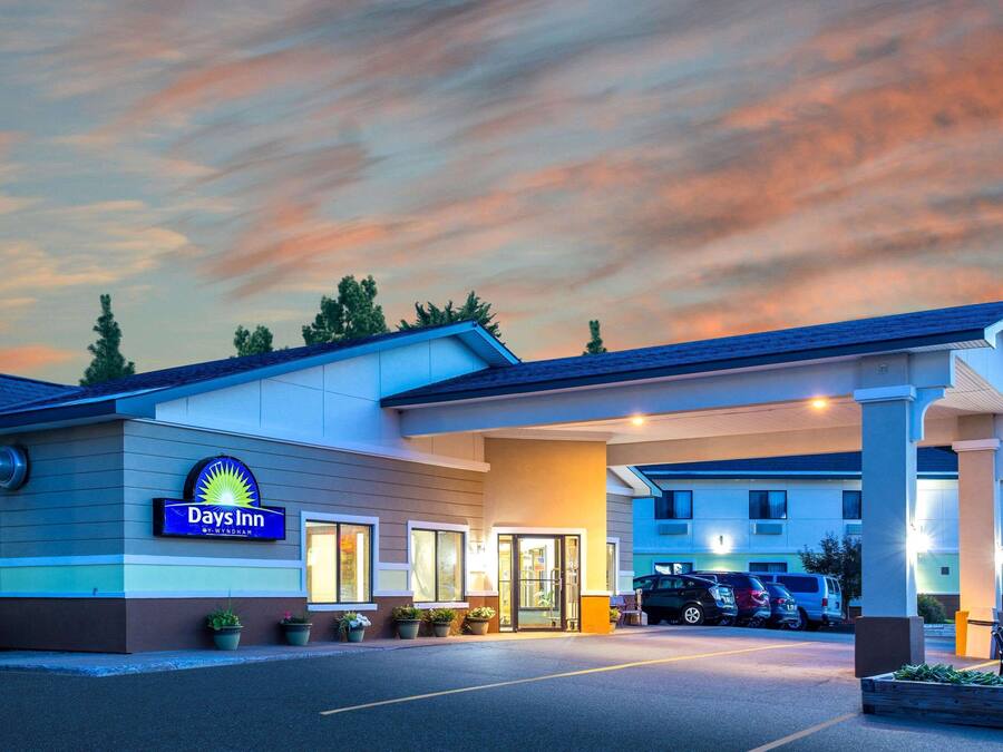 Ein Hotel der Days Inn mit modernem Design, erkennbar an der gut sichtbaren Beschilderung, dem überdachten Eingang und dem Parkplatz.