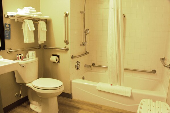 A bathroom with a toilet, sink, and bathtub. There are grab bars installed for safety. - Days Inn by Wyndham Marquette (Marquette)