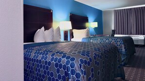 Een hotelkamer met een groot bed, twee nachtkastjes, een bureau en een stoel.