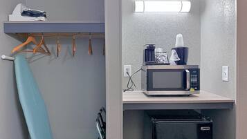 A compact kitchenette with a microwave, coffee maker, and small refrigerator.