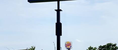 Un cartel grande de American Inn con un logotipo de Burger King cerca.