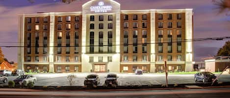 Un hotel de varios pisos con un letrero llamativo que dice 'CANDLEWOOD SUITES'.