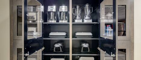 A kitchen with built-in appliances including a coffee maker, blender, and toaster.