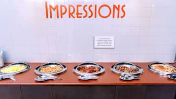 A buffet counter with five bowls of food and a sign warning about foodborne illness risks.