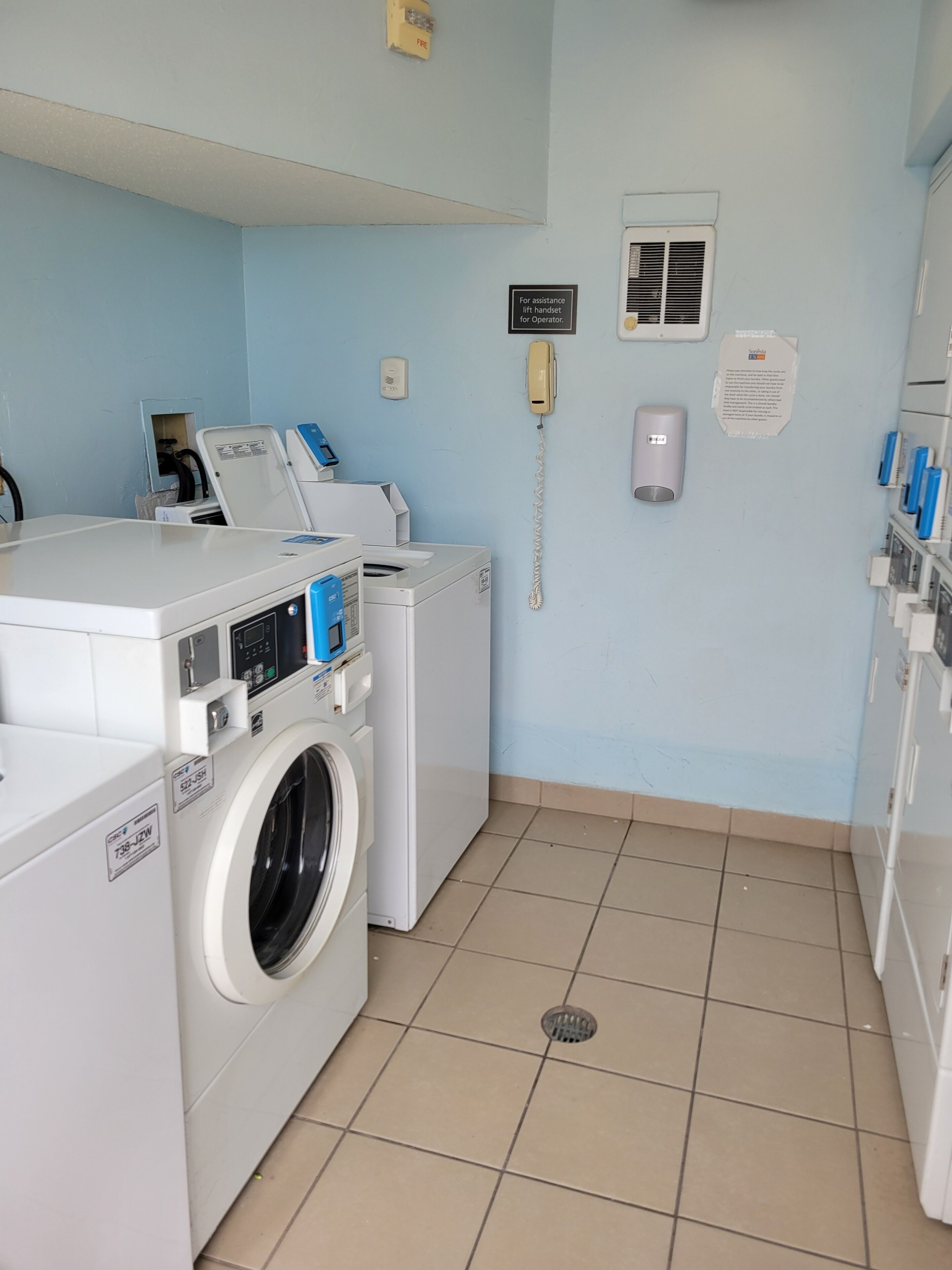 Une buanderie équipée d’un lave-linge, d’un sèche-linge et d’un téléphone.