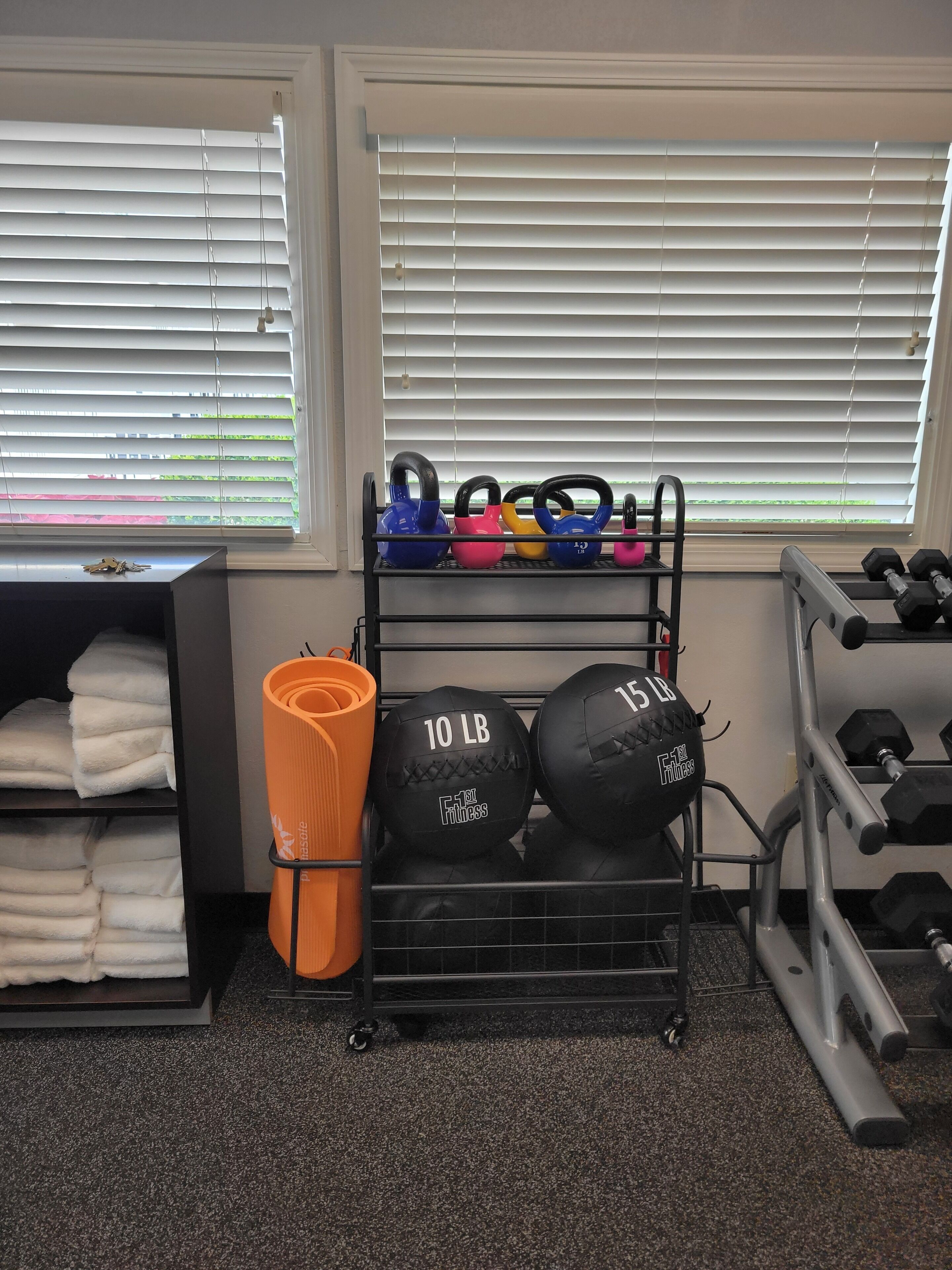 Une salle de sport équipée de kettlebells, d’haltères et d’un tapis de yoga.