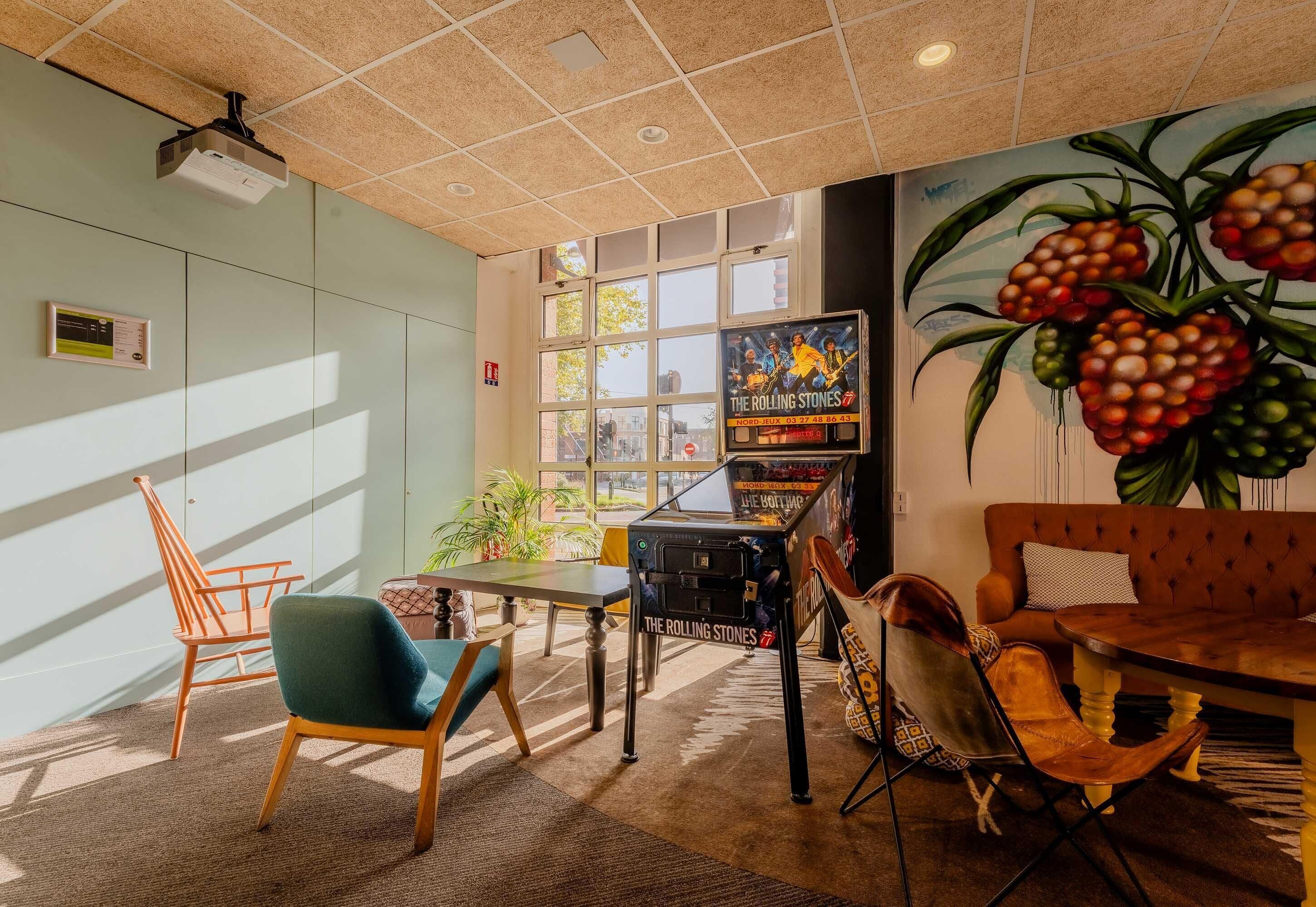 Una habitación con proyector, piano, sofá y un mural de frutas.