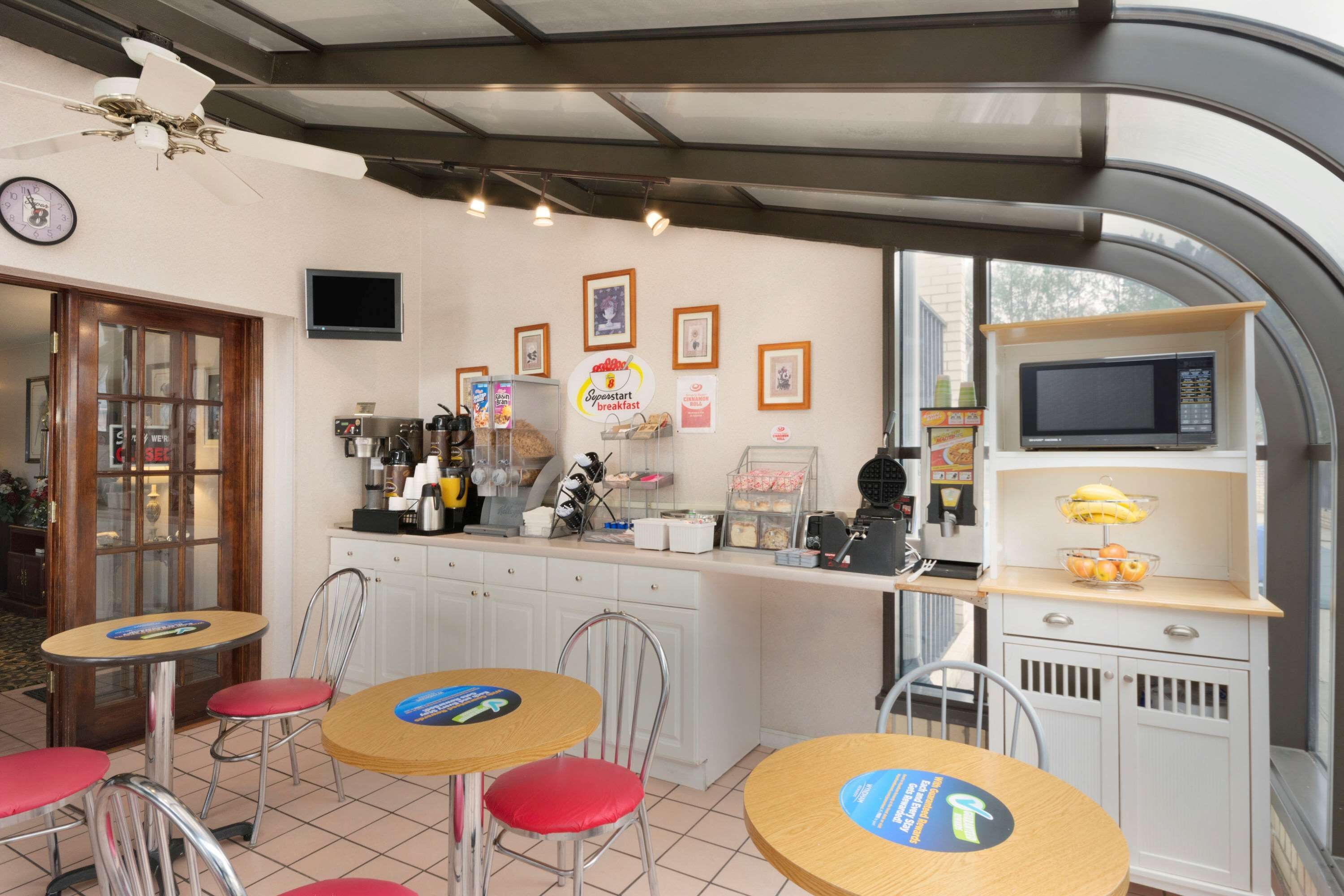 A breakfast area with a counter, chairs, and a microwave.