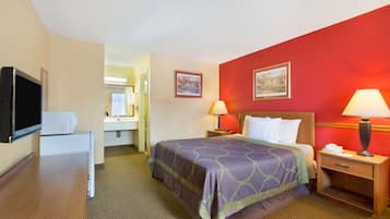 A hotel room with a bed, two bedside tables with lamps, a television, and a microwave.