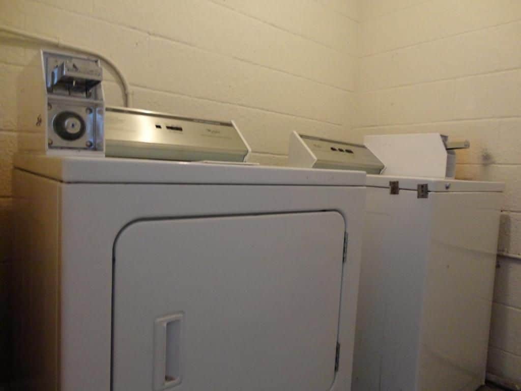 Una lavadora blanca con un panel de control y un dispensador de toallas de papel en la parte superior.