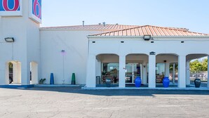 A motel with a white facade, numbered '6', and a covered entrance with large vases. - Motel 6 Round Rock, TX (Round Rock)