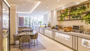 A modern kitchen with a breakfast bar, seating area, and large windows offering a view of the outdoors.