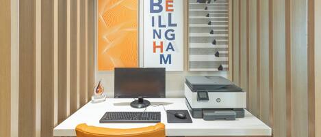 A modern office desk with a computer, keyboard, mouse, and printer.