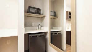A compact kitchen with a microwave, a coffee maker, and a dishwasher.