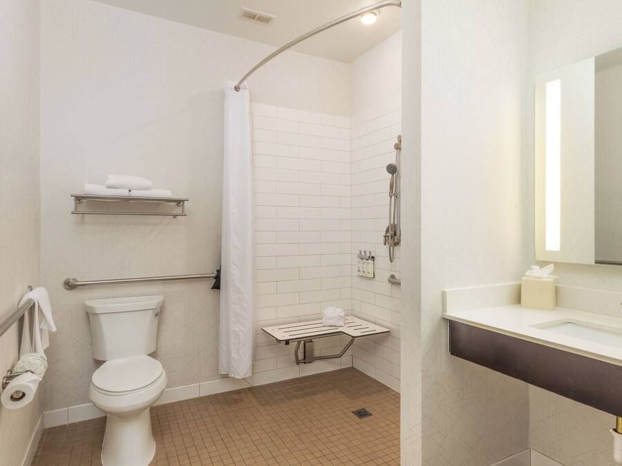 A bathroom with a toilet, shower, and sink.