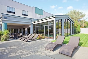 A modern building with a covered outdoor seating area and a glass enclosure. - Holiday Inn Express Bellingham by IHG (Bellingham)