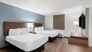 A hotel room with two beds, a flat-screen TV, a desk, and a window. - Suburban Studios Chester (Chester)