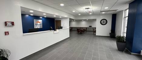 A spacious reception area with a blue accent wall, a clock, and a reception desk.