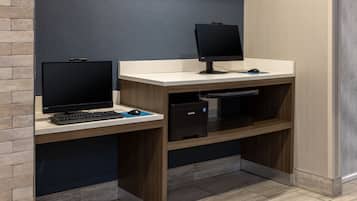 Ein moderner Arbeitsraum mit zwei Schreibtischen, jeweils ausgestattet mit einem Computermonitor, einer Tastatur und einer Maus.