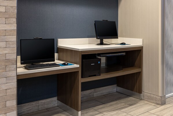 A modern office space with two desks, each equipped with a computer monitor, keyboard, and mouse.