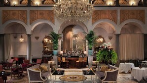 A luxurious lobby with a bar, seating arrangements, and decorative elements.