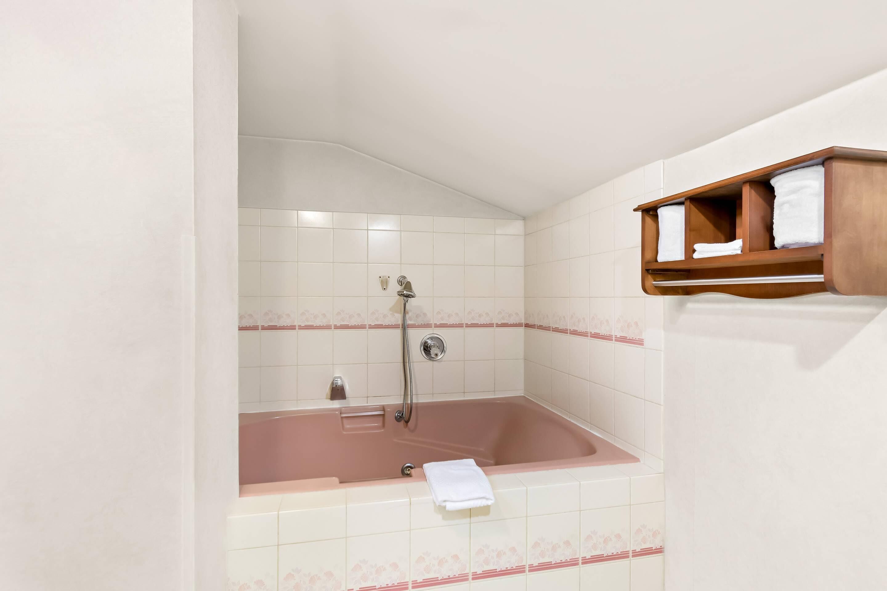 Un baño con bañera, ducha y un perchero para toallas.