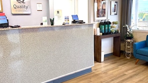 A hotel reception area with a reception desk, a computer, and a coffee station. - Quality Inn Mount Vernon (Mount Vernon)
